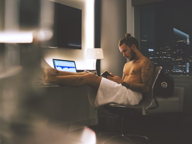 a man sitting down with a laptop front of him